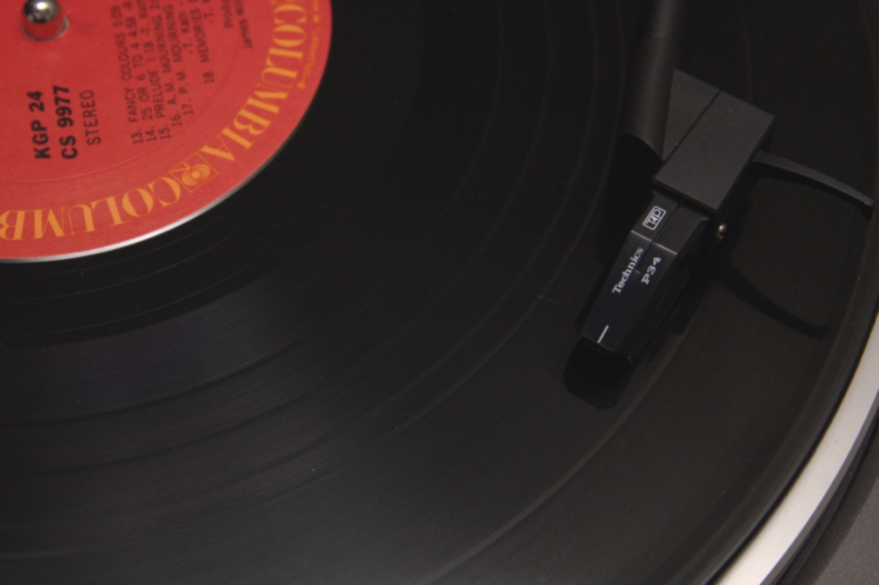 Close-up of a vinyl record with a red label on a turntable